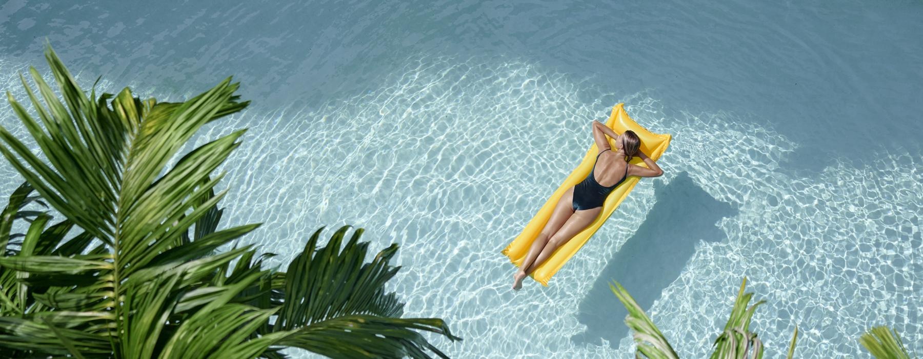 woman floating on a floatie in a pool